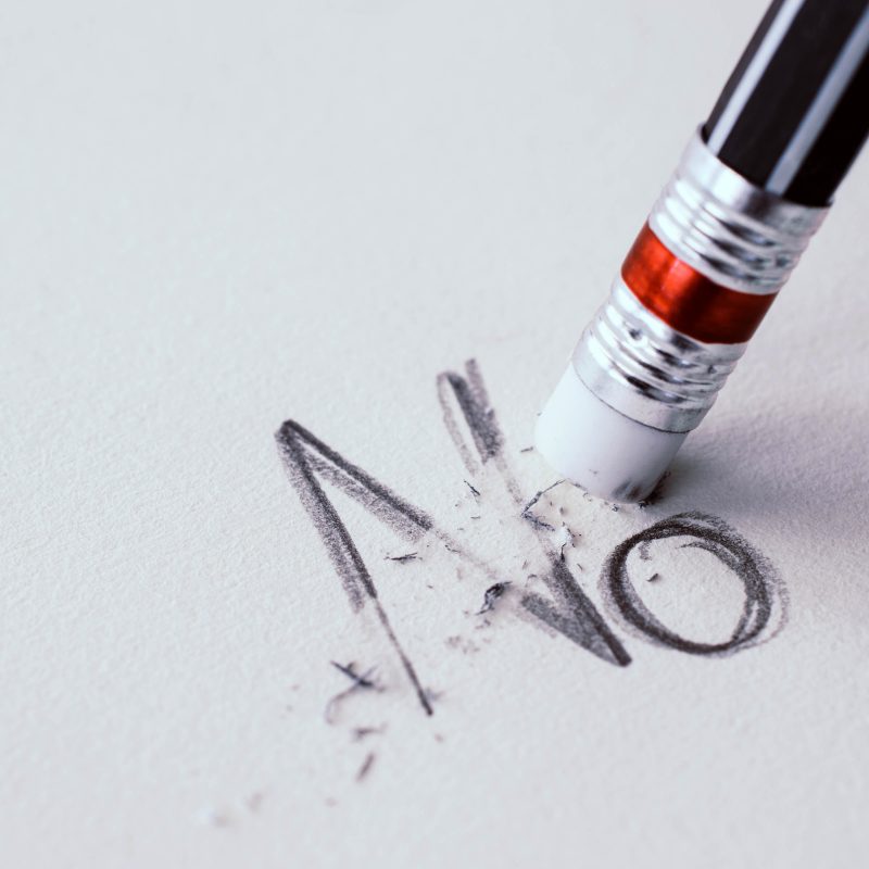 pencil erasing the word No on paper.